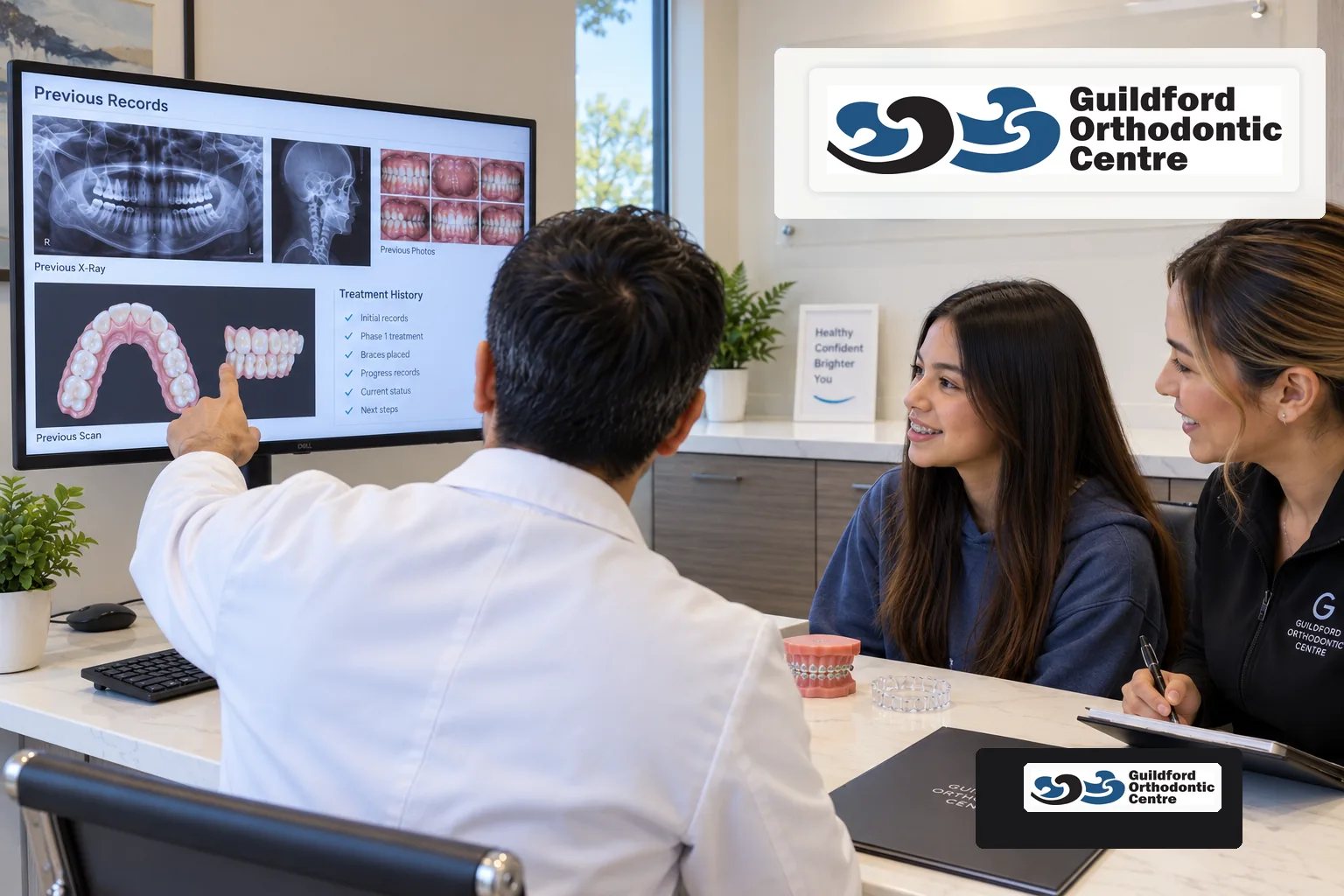 Orthodontist reviewing previous X-rays, scans and treatment records with a transfer patient wearing braces.